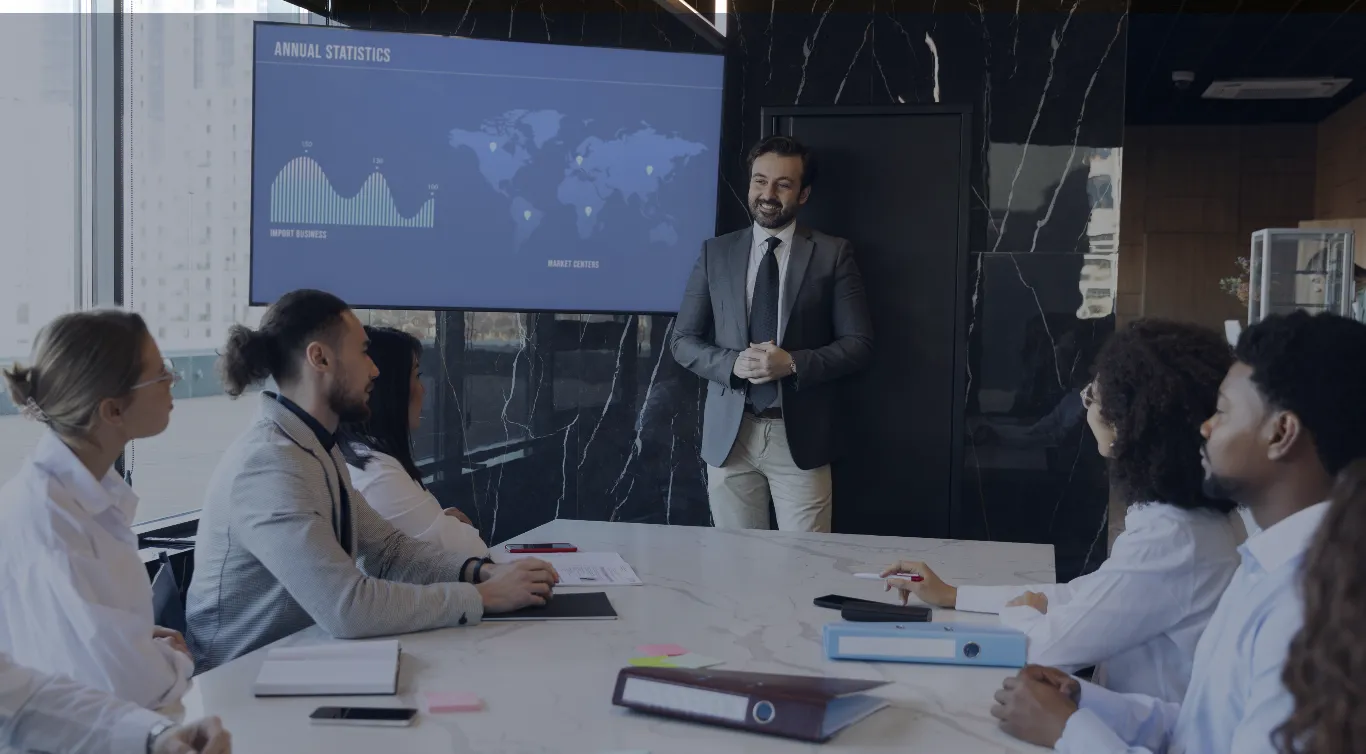 A manager presenting annual statistics to colleagues around a conference table