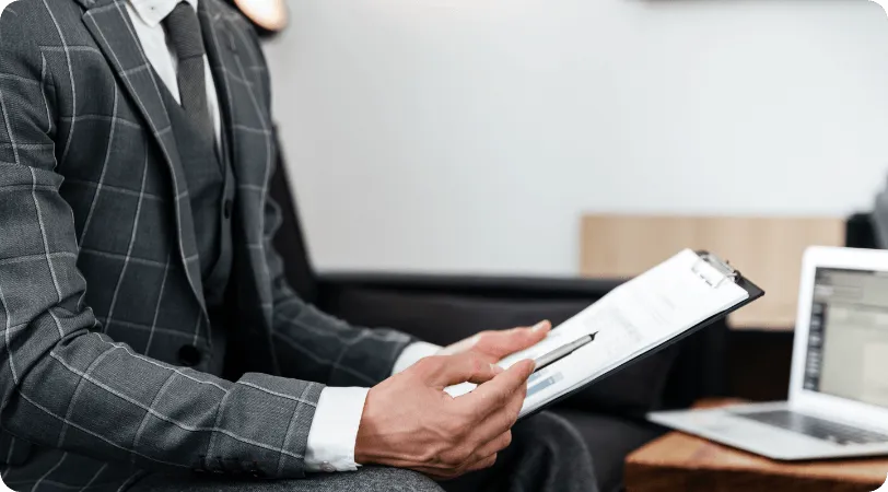 Hotel manager holding a clipboard next to a laptop